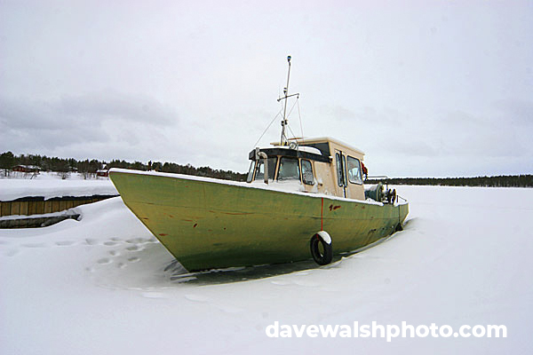 Boat on frozen lake, Lapland, Finland