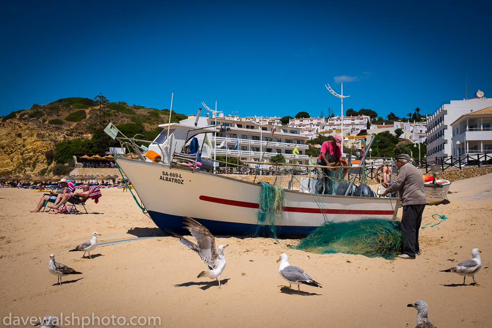 Fishermen cleaning nets in Salema