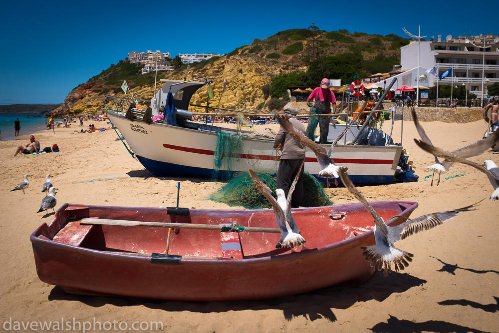 Fishermen cleaning nets in Salema