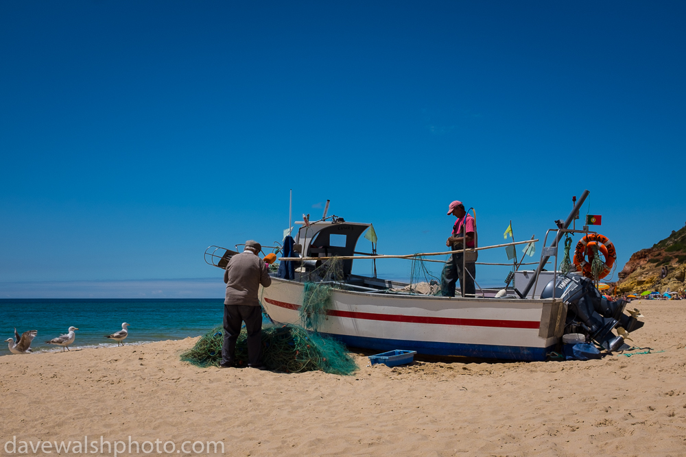 Fishermen cleaning nets in Salema