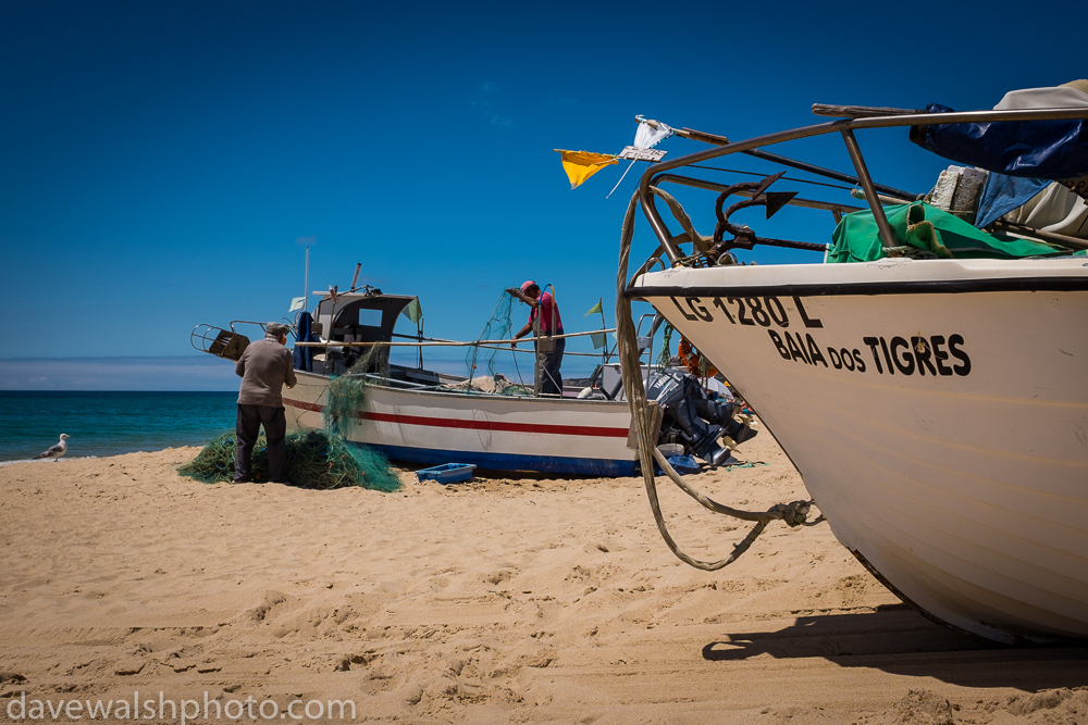 Fishermen cleaning nets in Salema